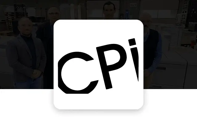 A group of people standing in an industrial warehouse, smiling, with stacks of goods and machinery in the background. A white "CPi" logo overlays on the right.