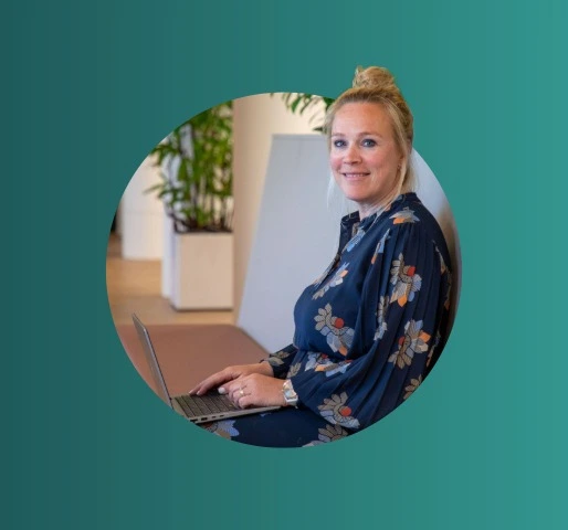 Persoon werkt op een laptop in een kantooromgeving.