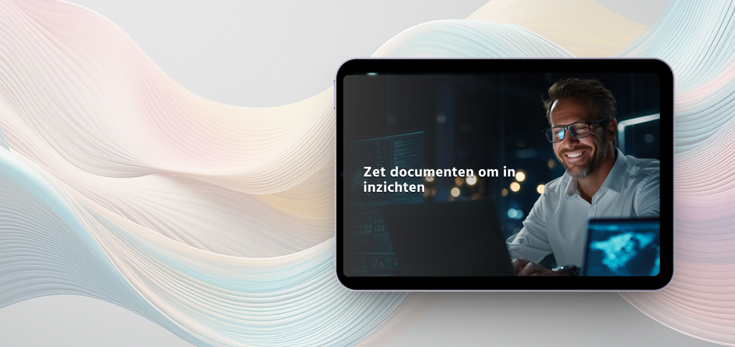 A smiling man in glasses works on a computer in a dimly lit office. Text reads: 